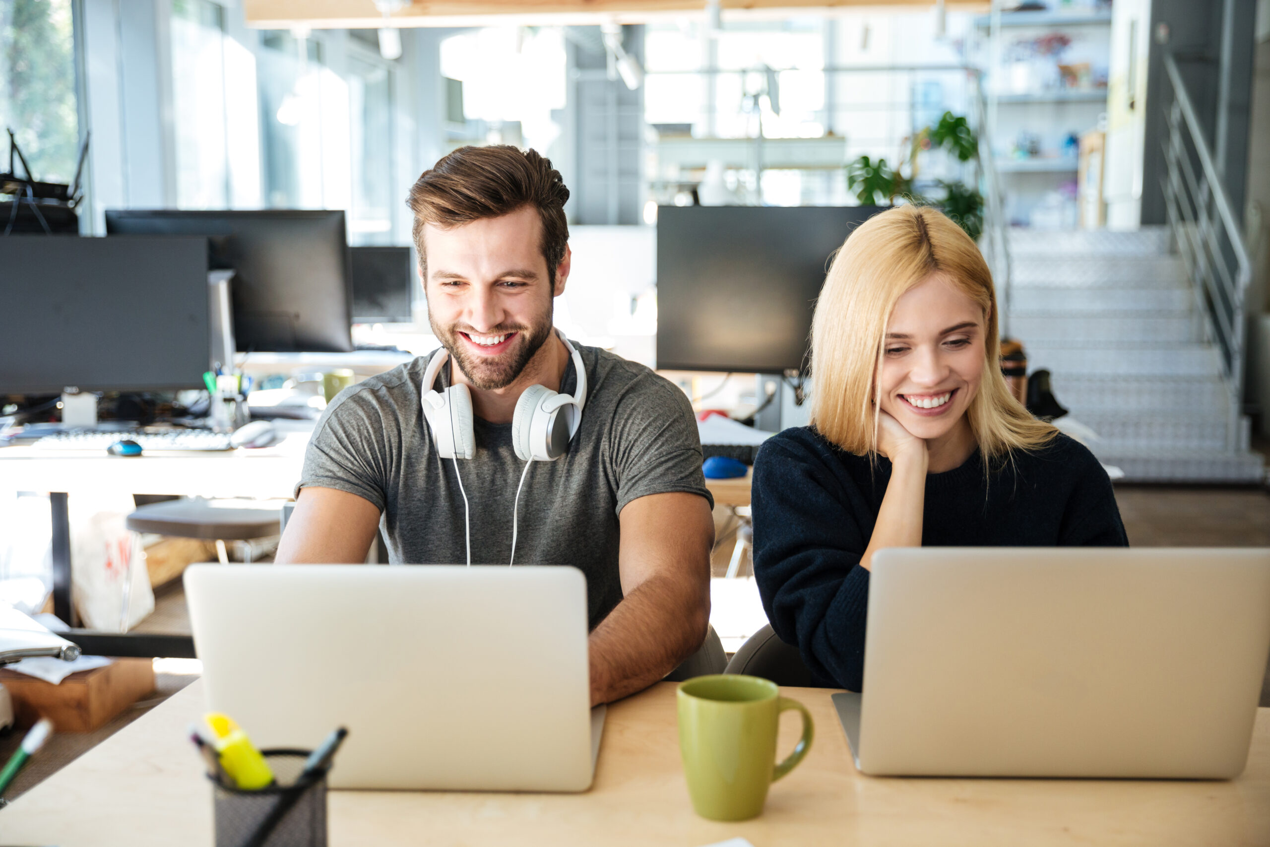 smiling young colleagues sitting office coworking scaled